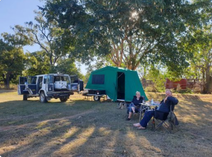 Picture of pop up tent on camper, there is a tyre swing hanging on a tree and there is a nice lawn and plenty of shade.