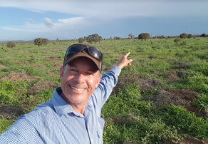 Picture of Carl Hendrick pointing to the paddock on this working farm stay near Rockhampton.