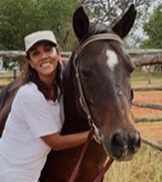 Picture of smiling woman hugging a bay horse.  Myella offers horse experiences for riding for disabled person, there is even a wheelchair ramp.