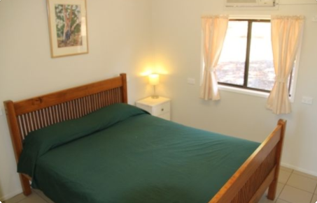 Picture of inside an ensuite double room.  There is an air-conditioner, fridge, fan, shower and toilet in these motel style rooms.  Myella offers rooms with private bathrooms near Baralaba, Woorabinda, Banana and Duringa Motel.